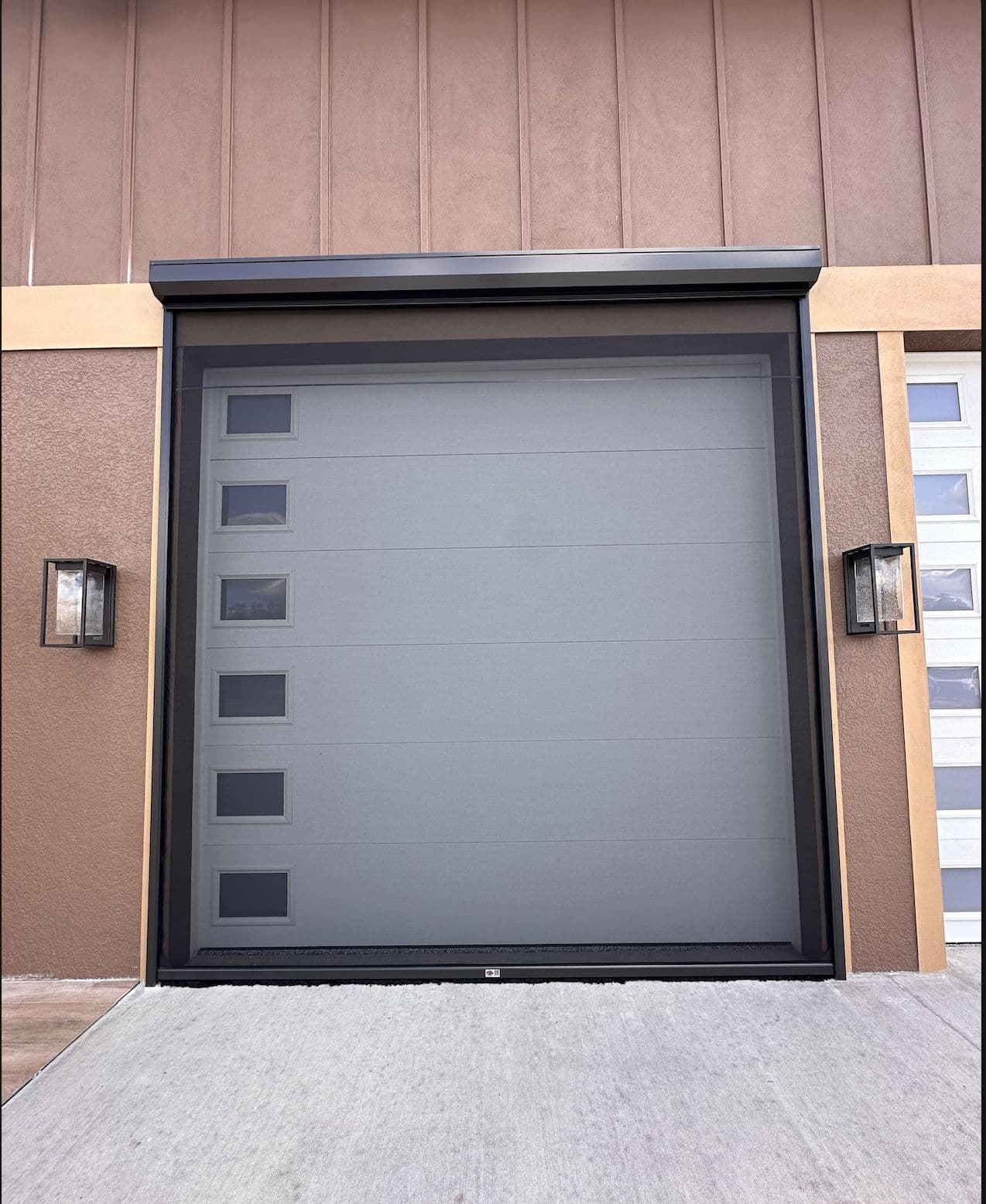 Gray roll-down shutter closed over a large ground-floor opening
