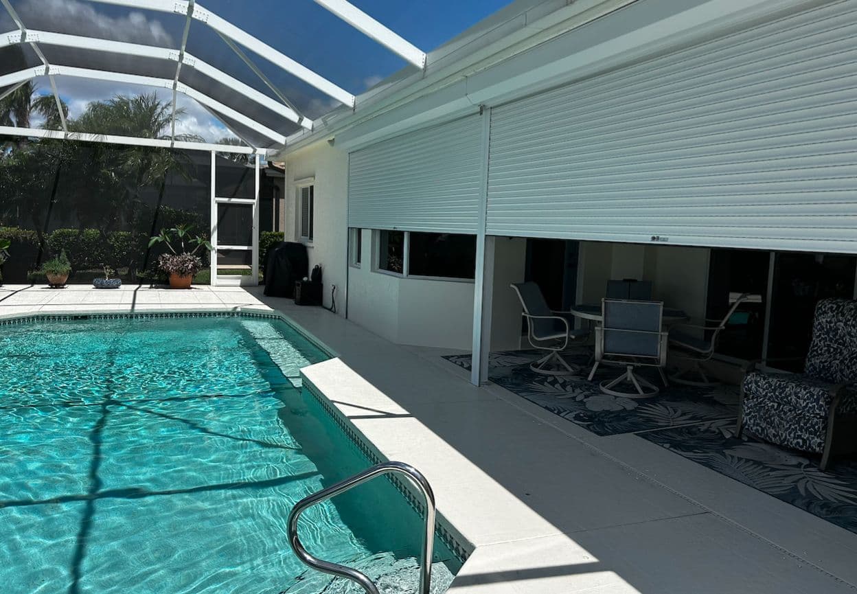 White shutters lowered across a pool lanai
